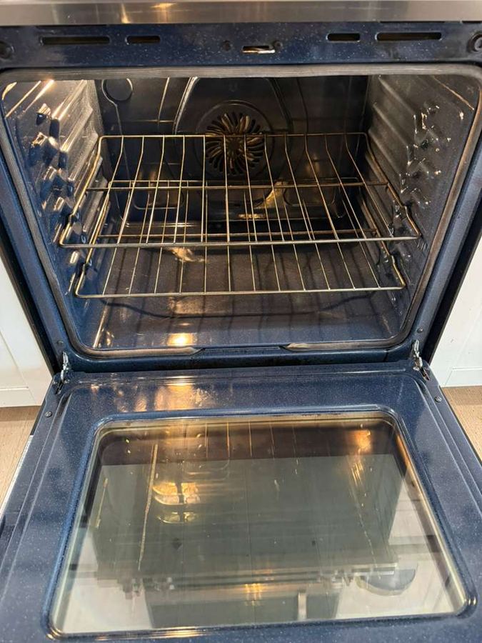 Same oven interior after cleaning, spotless glass and racks