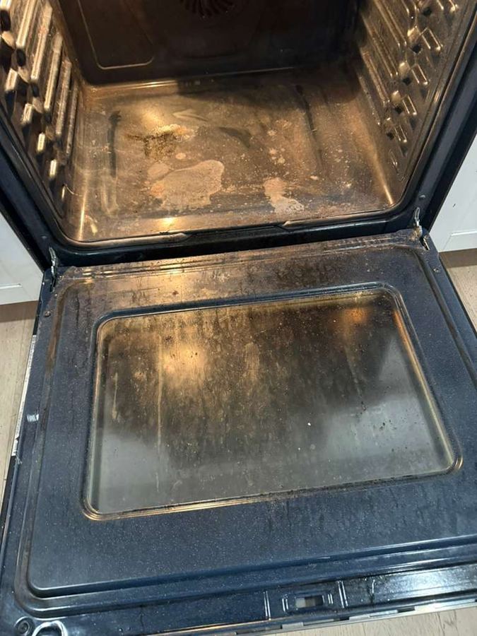 Oven interior before cleaning, covered in baked-on grease and grime