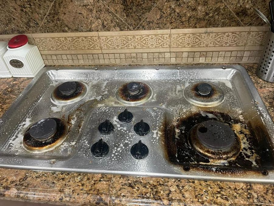 Stovetop before cleaning, heavy burnt grease around burners