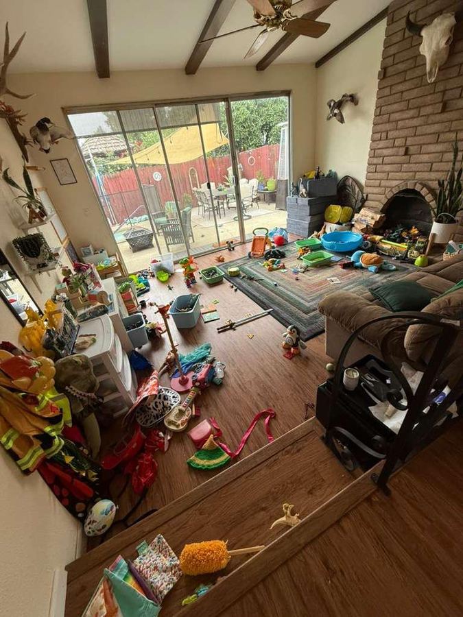 Living room floor before organizing, covered in scattered toys